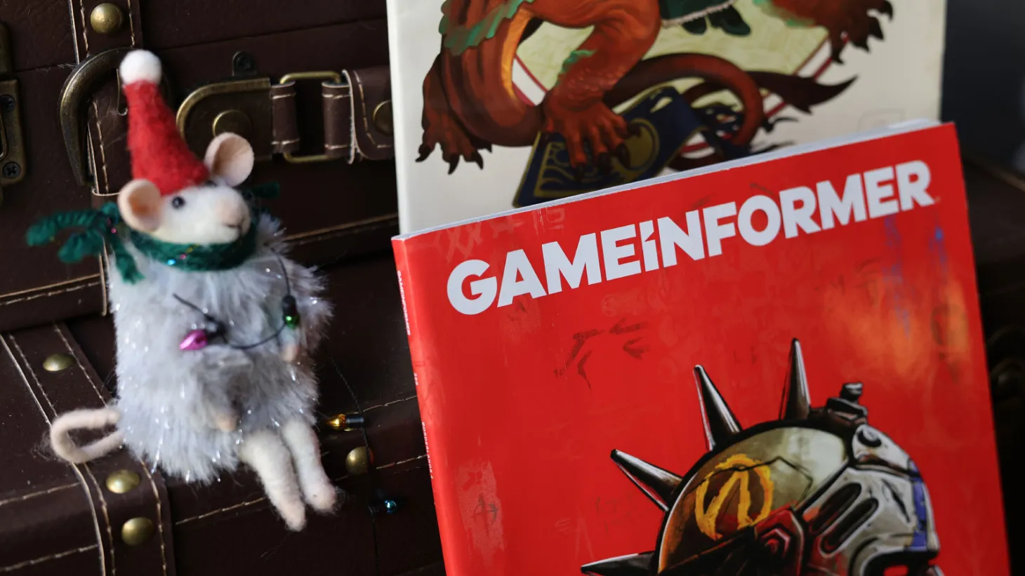Mouse sitting next to issues of Game Informer